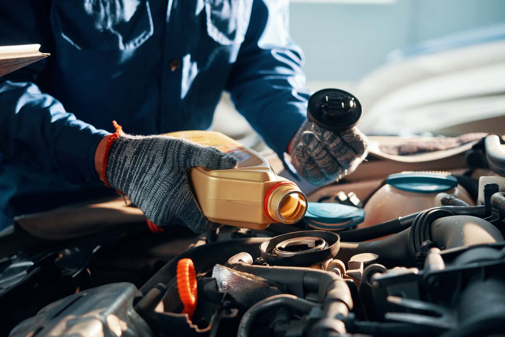 Mechanic adding fluids to a car engine