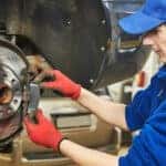 A mechanic replaces old brake pads