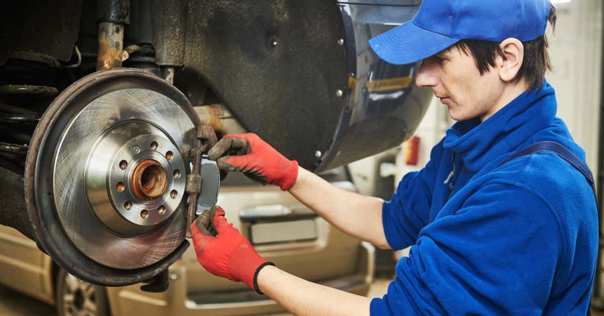 A mechanic replaces old brake pads