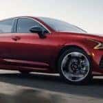 Red Kia sedan driving