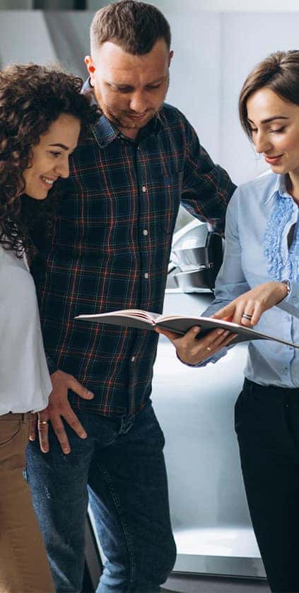 Leasing versus Buying a Toyota at CMA's Toyota of Martinsburg in Martinsburg, WV | Sales person showing a couple the documents forms for leasing a car