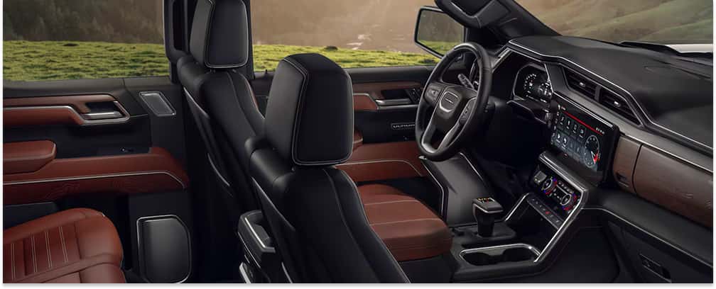 Interior view of a 2026 GMC Sierra 1500 showing brown leather seats, digital infotainment screen, and dashboard.