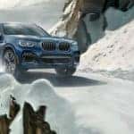 Blue BMW crossover in wintery mountain road