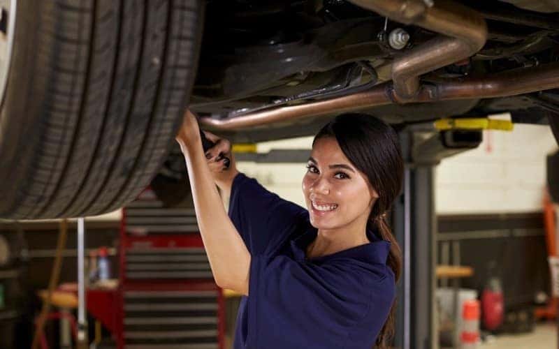 female working under car stock image