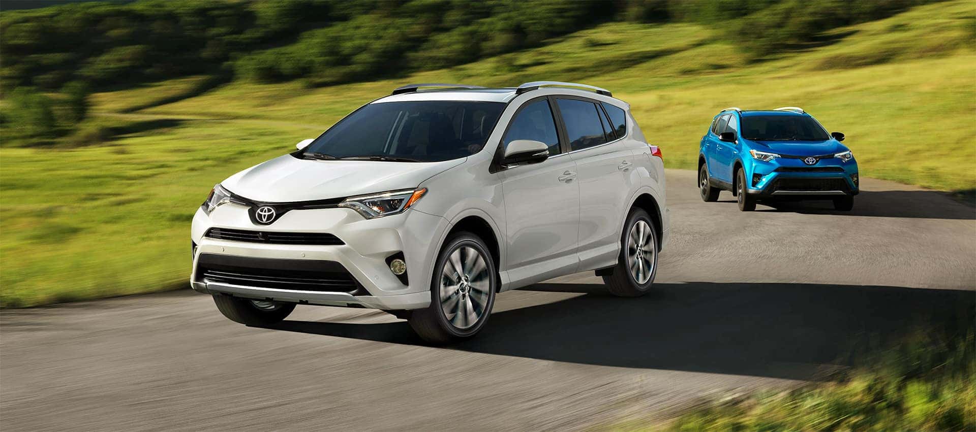 Hanover Toyota is a Toyota Dealership in Hanover near York PA | White RAV4 Racing Blue RAV4 Grassy Turn
