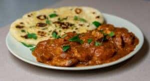 Roti and meat slices on a plate with sauce
