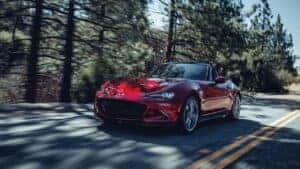 2023 Mazda MX-5 Miata Driving on a road with a forest in the background