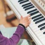 person playing piano by Siniz Kim is licensed with Unsplash License