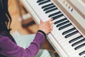 person playing piano by Siniz Kim is licensed with Unsplash License