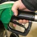 Person putting premium fuel in their Mazda vehicle at a gas station