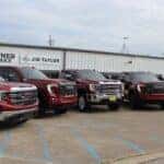 Red GMC Sierra 1500 and Sierra HD pickups lined up at Jim Taylor Buick GMC in Monroe, LA