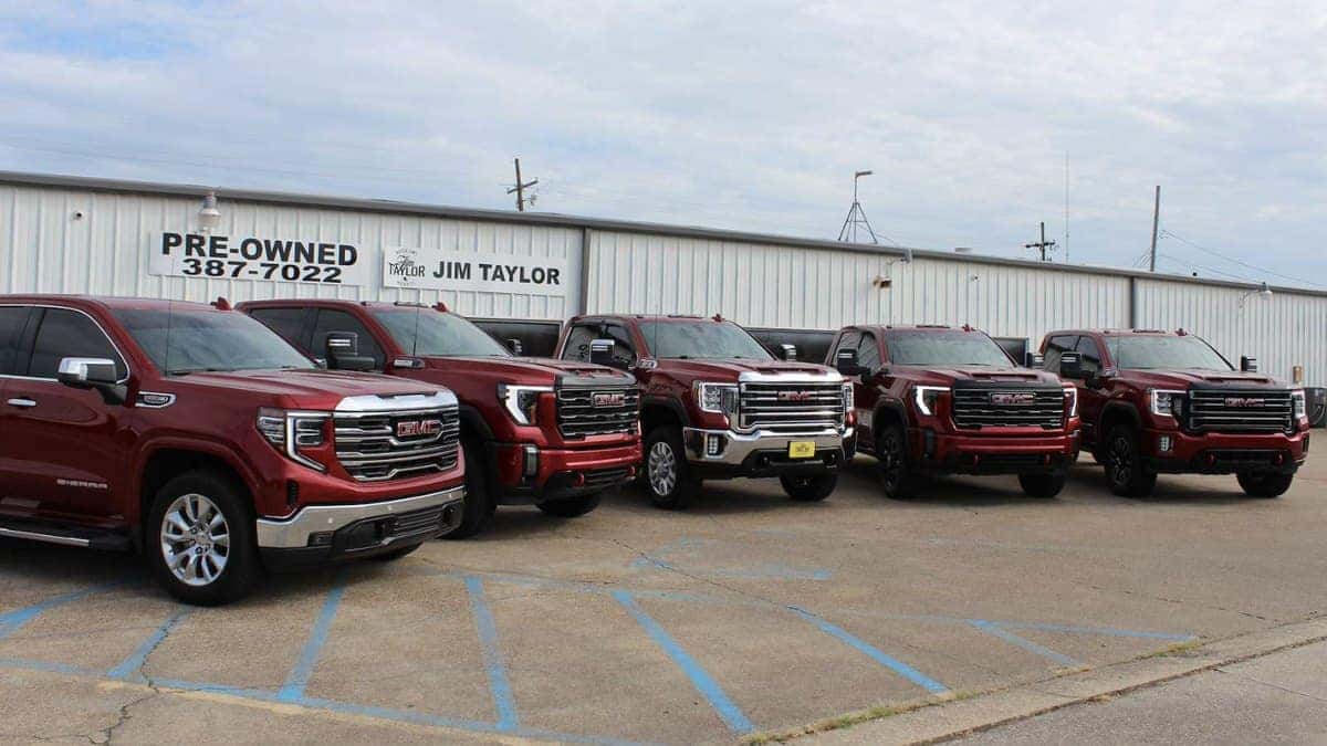 Red GMC Sierra 1500 and Sierra HD pickups lined up at Jim Taylor Buick GMC in Monroe, LA