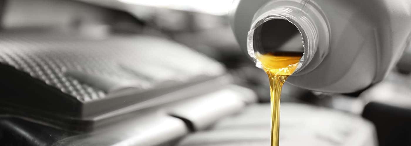 Pouring oil into car engine, closeup