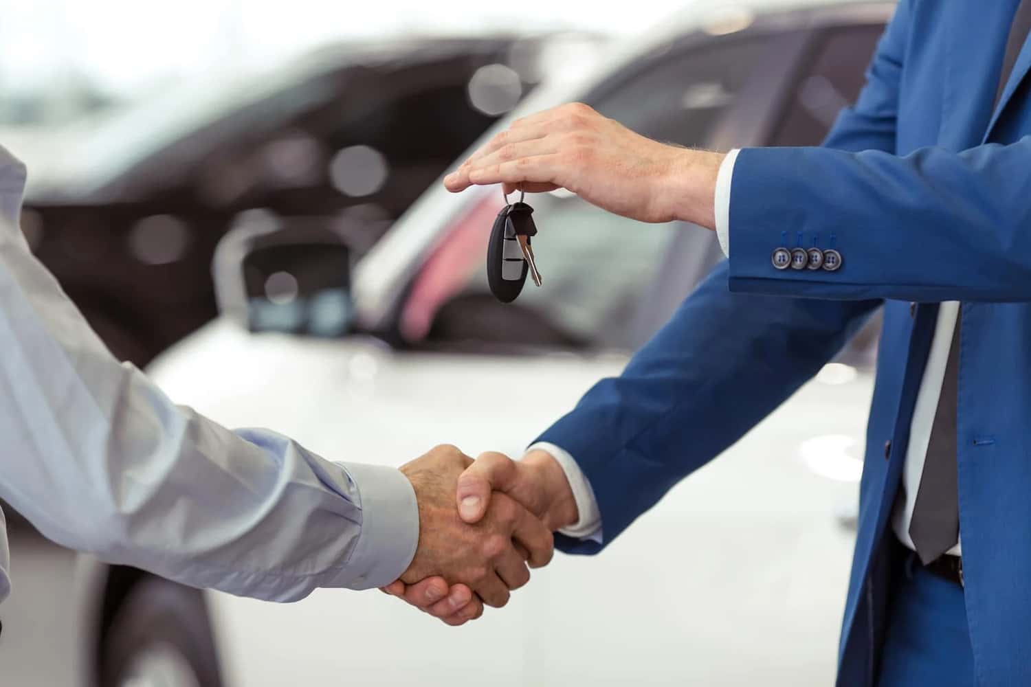 Volkswagen Finance team member shaking hands with customer while handing them the keys to their new VW