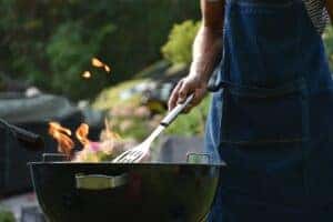 An open flame over a grill as barbecue meat is cooked