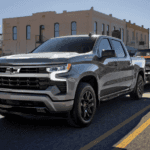 2026 Chevrolet Silverado 1500 towing a classic car on a city street