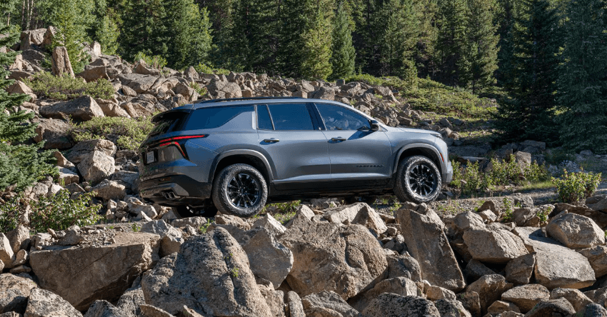 2026 Chevrolet Traverse driving over rocky terrain in the mountains