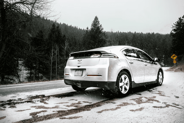 Silver Chevrolet hatchback driving on a snowy road