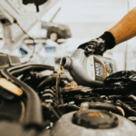 Technician pouring engine oil during vehicle service