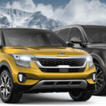 Kia SUVs parked in foreground with mountains in background