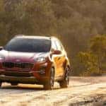 Red Kia Sportage driving on mountain road
