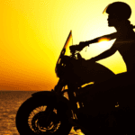 Woman driving motorcycle in sunset