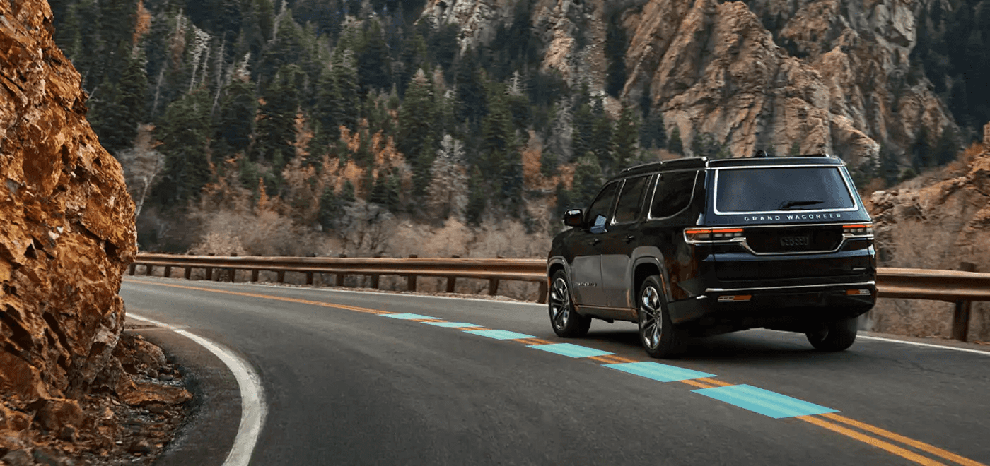 2022 Jeep Wagoneer driving away on mountain road
