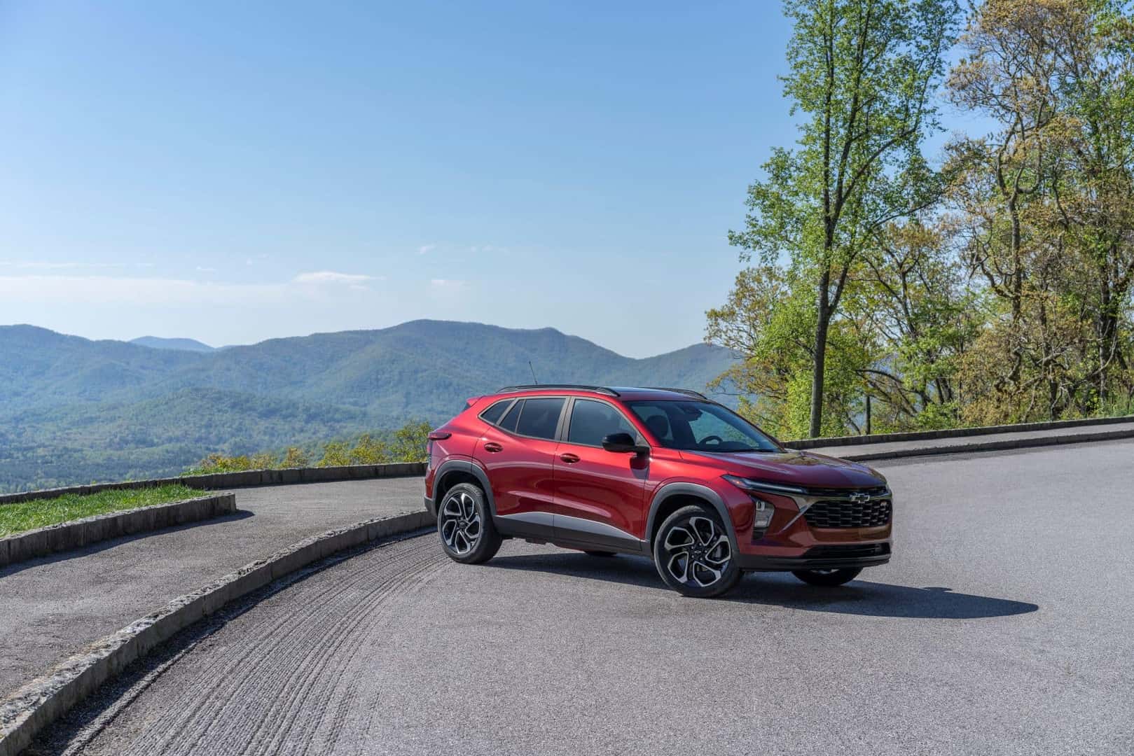 The Impressive And Versatile 2024 Chevy Trax, Parked Epically On A Road, Near A Mountain Edge With An Excellent View