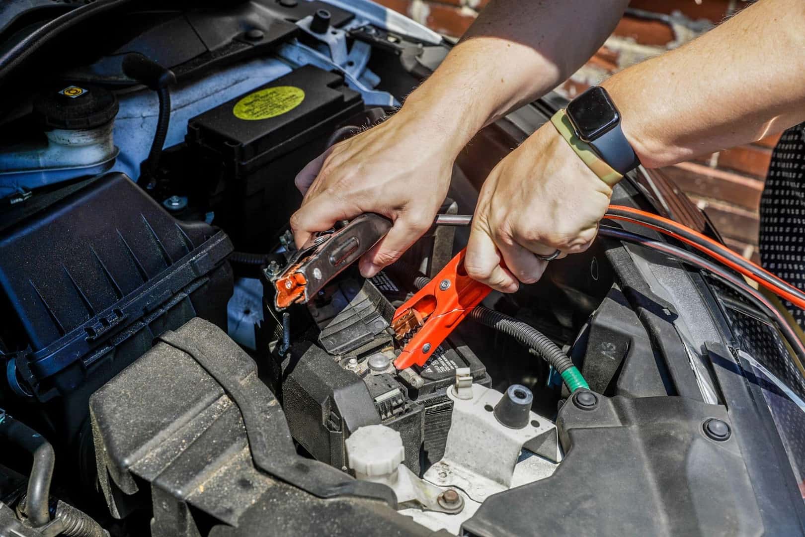 A Driver Using Their Jumper Cables To Start Their Car Again
