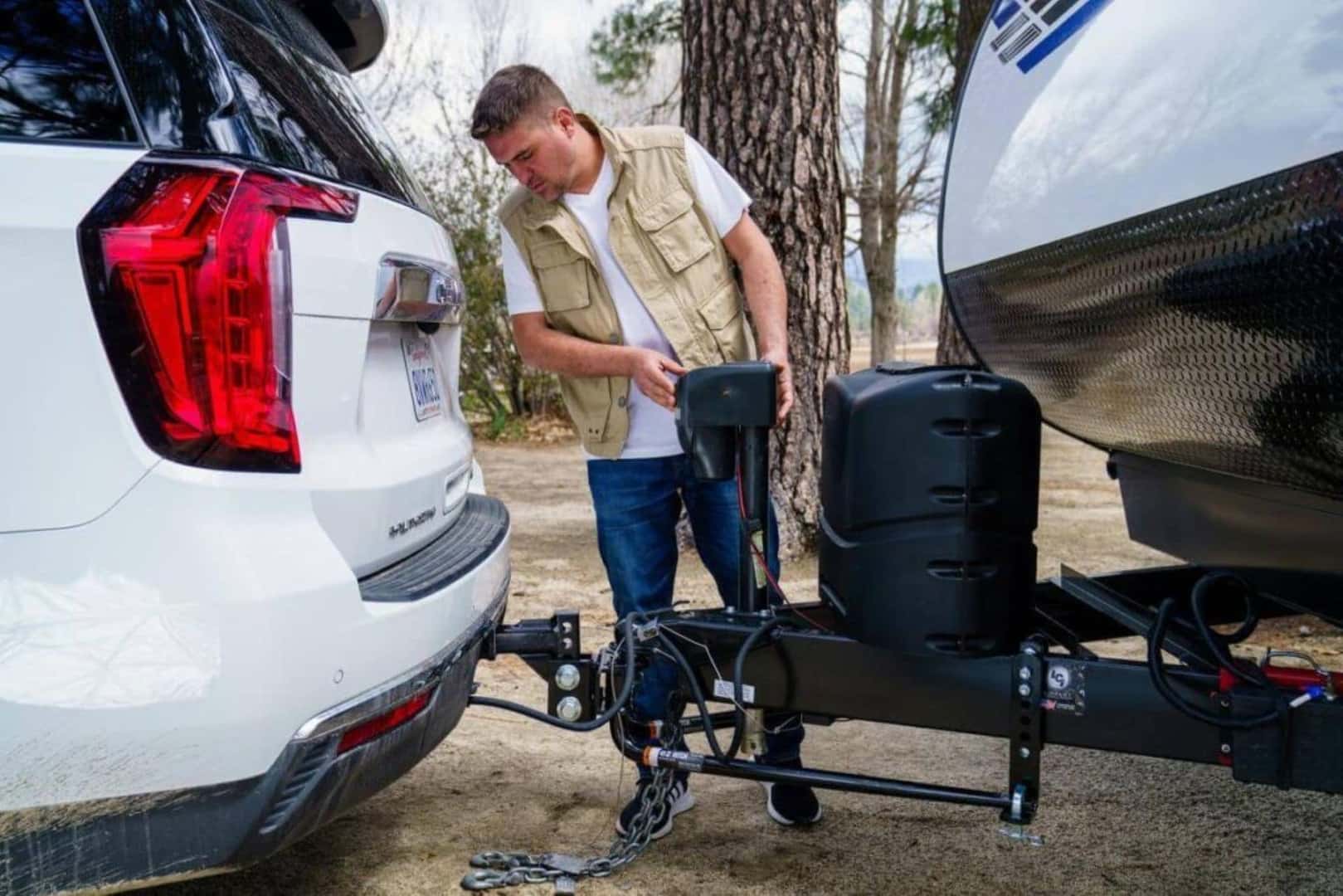 A Man Attaching An RV To The SUV's Tongue