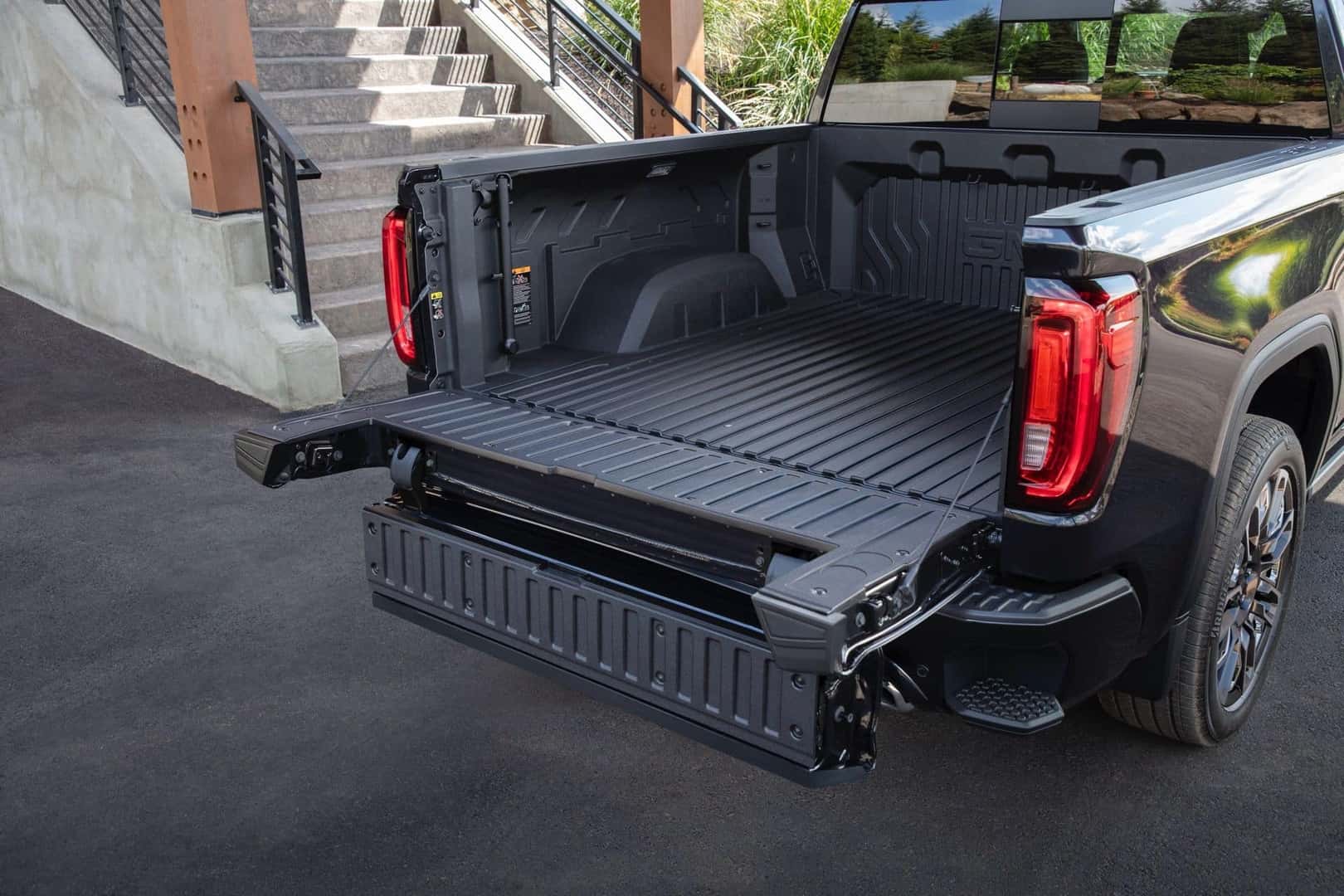 The Fabulous And Expansive Cargo Bed Of The Strong And Mighty 2024 GMC Sierra Denali, Parked Near The Steps Of A Home