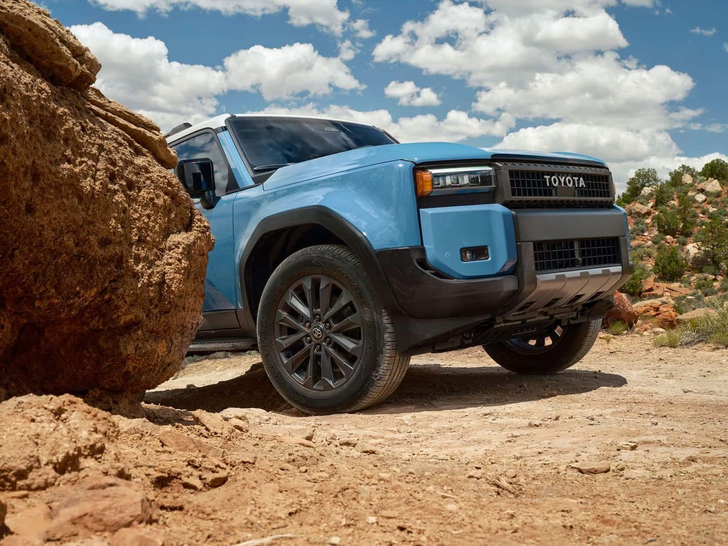 The Off-Roading Beast: The 2025 Toyota Land Cruiser Peeking Behind A Rock