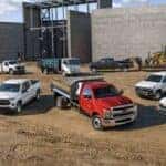 A Stellar Lineup Of Chevrolet Commercial Vehicles, Parked Outside A Building In Construction