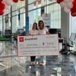 The Millionth SmartPath Customer Photographed With The Signed Check, Under A Balloon Arch