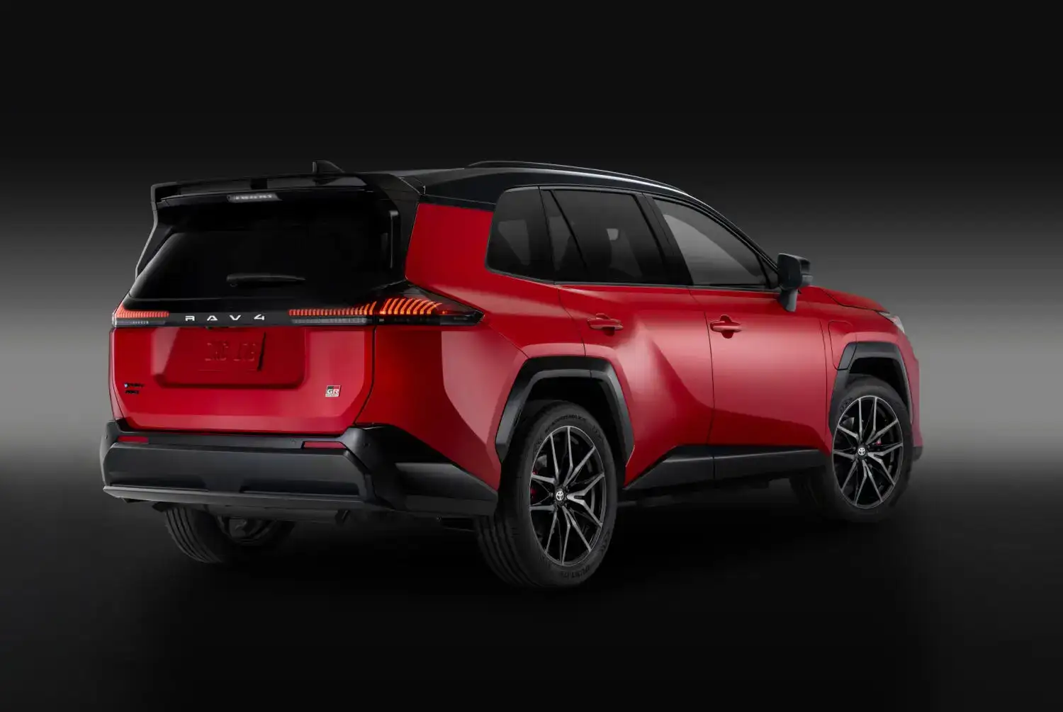 2026 red Toyota Rav4 rear view with a black and gray background