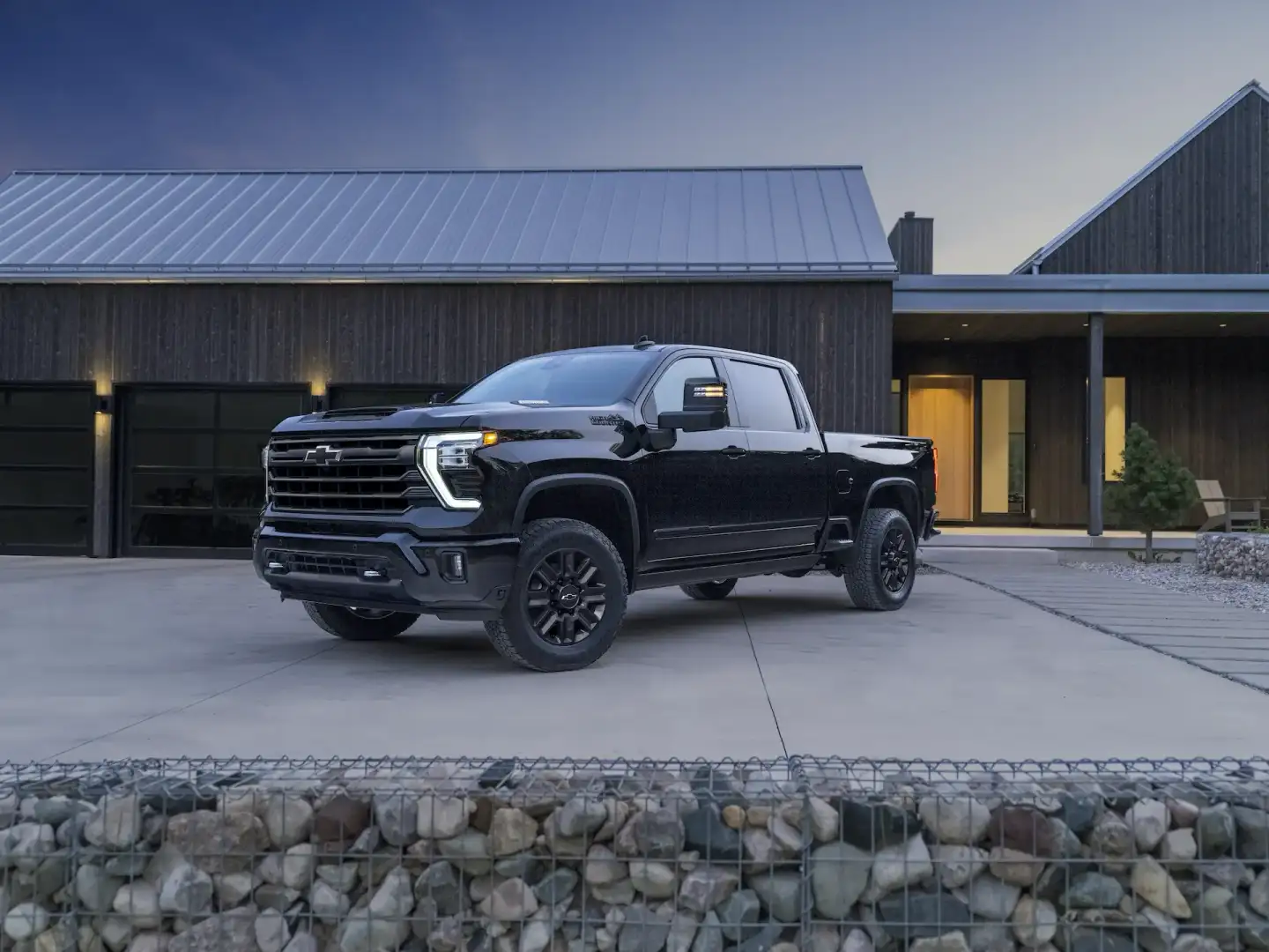 Black Chevrolet Silverado 2500 HD High Country parked at a house in the driveway