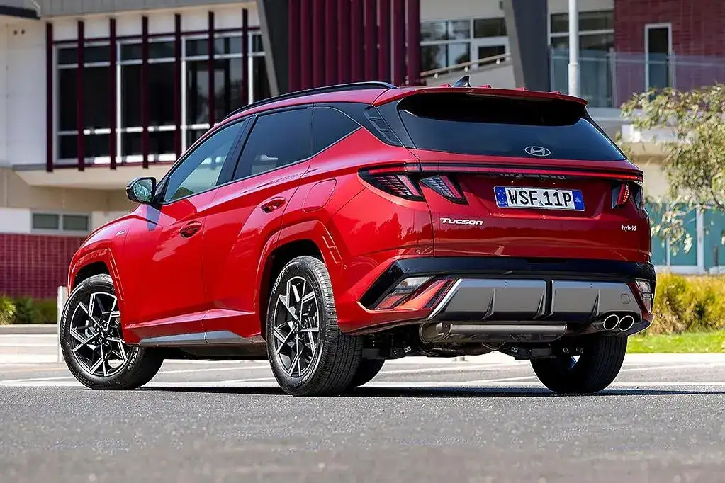 Red 2026 Hyundai Tucson HEV parked on a city street