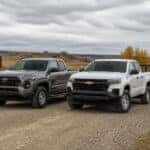 2026 Toyota Tacoma and 2026 Chevrolet Colorado parked on a South Dakota gravel road for a light-duty work comparison