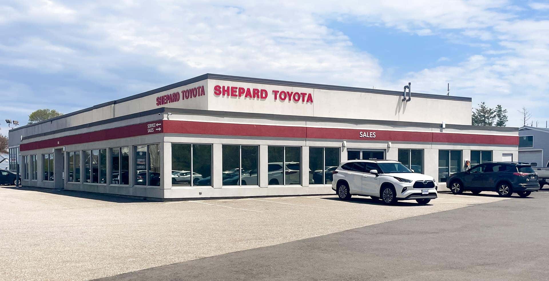 Front of the dealership with white, red and grey vehicles