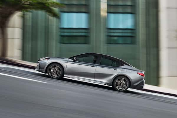 Illustration of Toyota AWD System: It is raining and a vehicle with a transparent body (revealing the tires and axel underneath, with arrows pointing forward to illustrate the drive system) is turning a corner