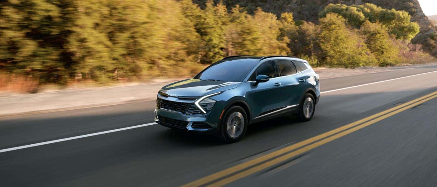 2025 Kia Sportage Hybrid Exterior Driving Fast Down Road