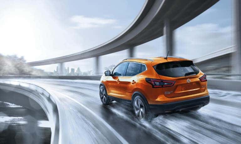 2020 Nissan rogue Sport in orange driving on wet highway