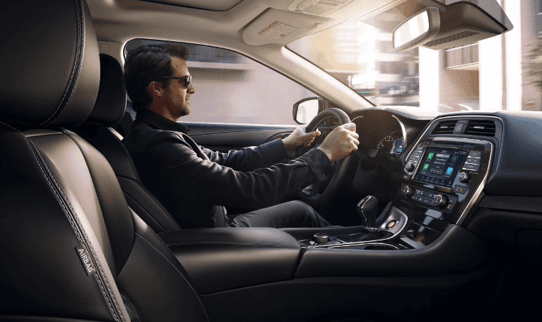 A man driving a Nissan