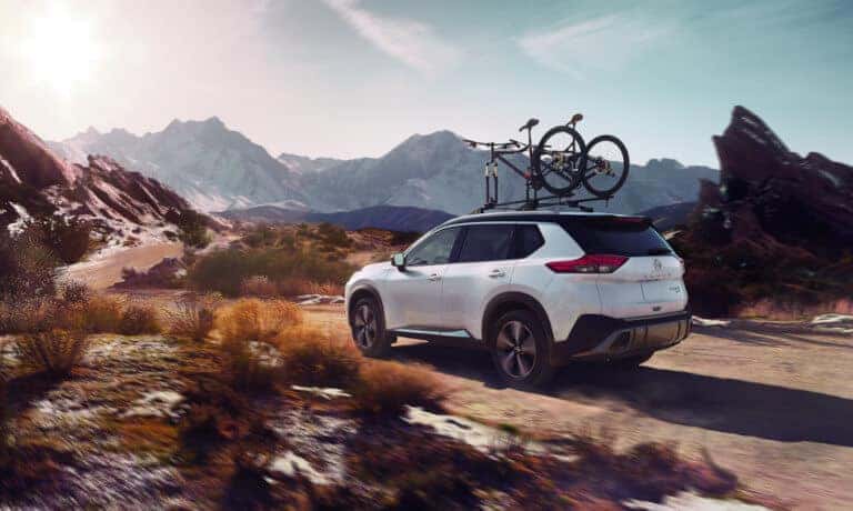Nissan Rogue Exterior Driving In Mountains With Bike Rack