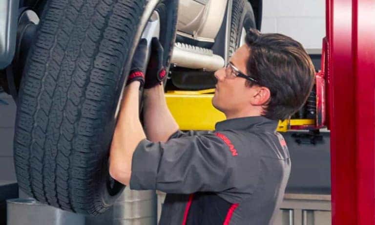 Nissan Service Technician Replacing Tire