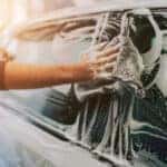 man soaping his car. close-up hand drawing