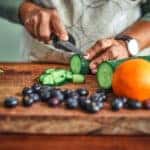 person meal prepping by chopping vegetables