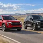 Red Chevrolet Trax and black Chevrolet Trailblazer driving side by side on a highway