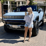 A young lady in front of a Hummer EV