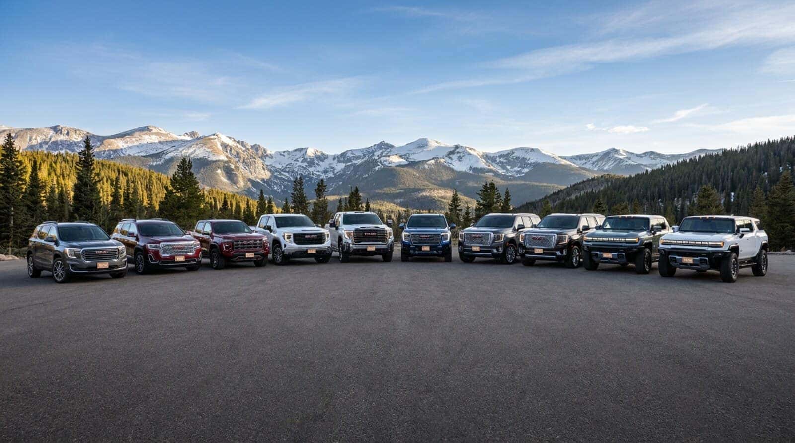 The complete 2026 GMC and Hummer EV lineup with the Colorado Rocky Mountains behind at Weld County Garage GMC in Greeley